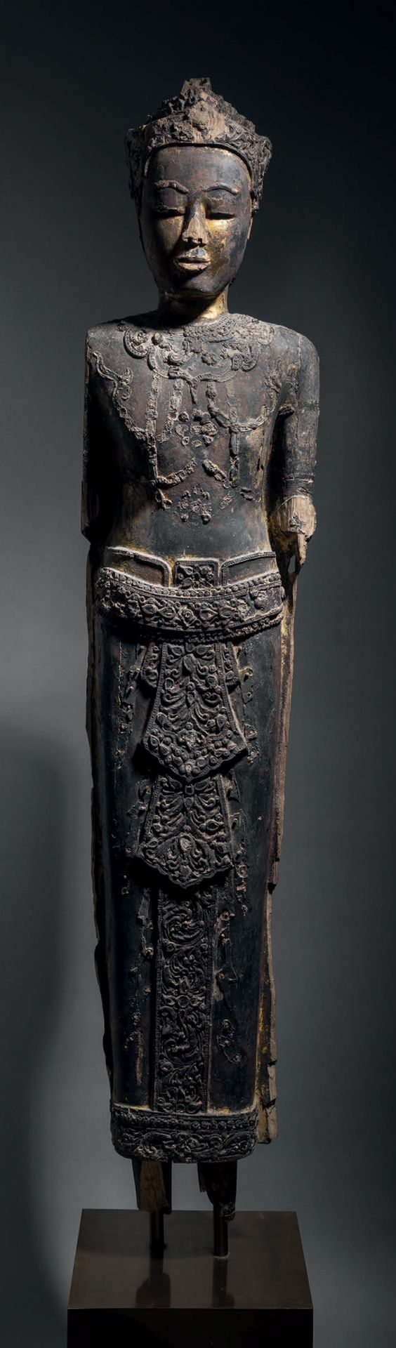 Null 站立装饰的佛像，柬埔寨，17世纪，高127厘米。漆面和镀金的木材，镶嵌玻璃
佛祖的面容很安详，杏仁形的眼睛半闭着，嘴唇相连，眉毛上扬。佛袍的装饰是用模&hellip;