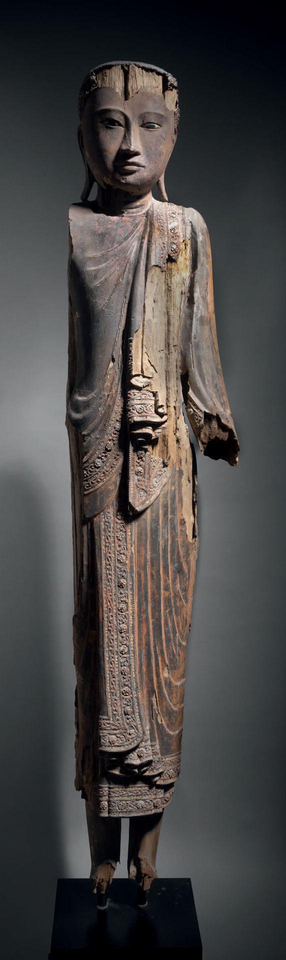 Null 立佛，缅甸 18-19世纪 高144厘米。漆面和镀金木，玻璃镶嵌
佛祖是站着的，身穿曼德勒地区特有的带有许多宽褶的僧侣袍。佛祖的面容是安详的，杏仁形的&hellip;