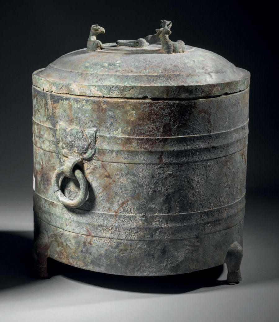 Null 九尊筒形花瓶，越南（公元前1世纪-公元2世纪）
H.28 cm - D. 27 cm。铜合金
花瓶三足站立，装饰有两条横带，在上面的横带上，固定有两个&hellip;