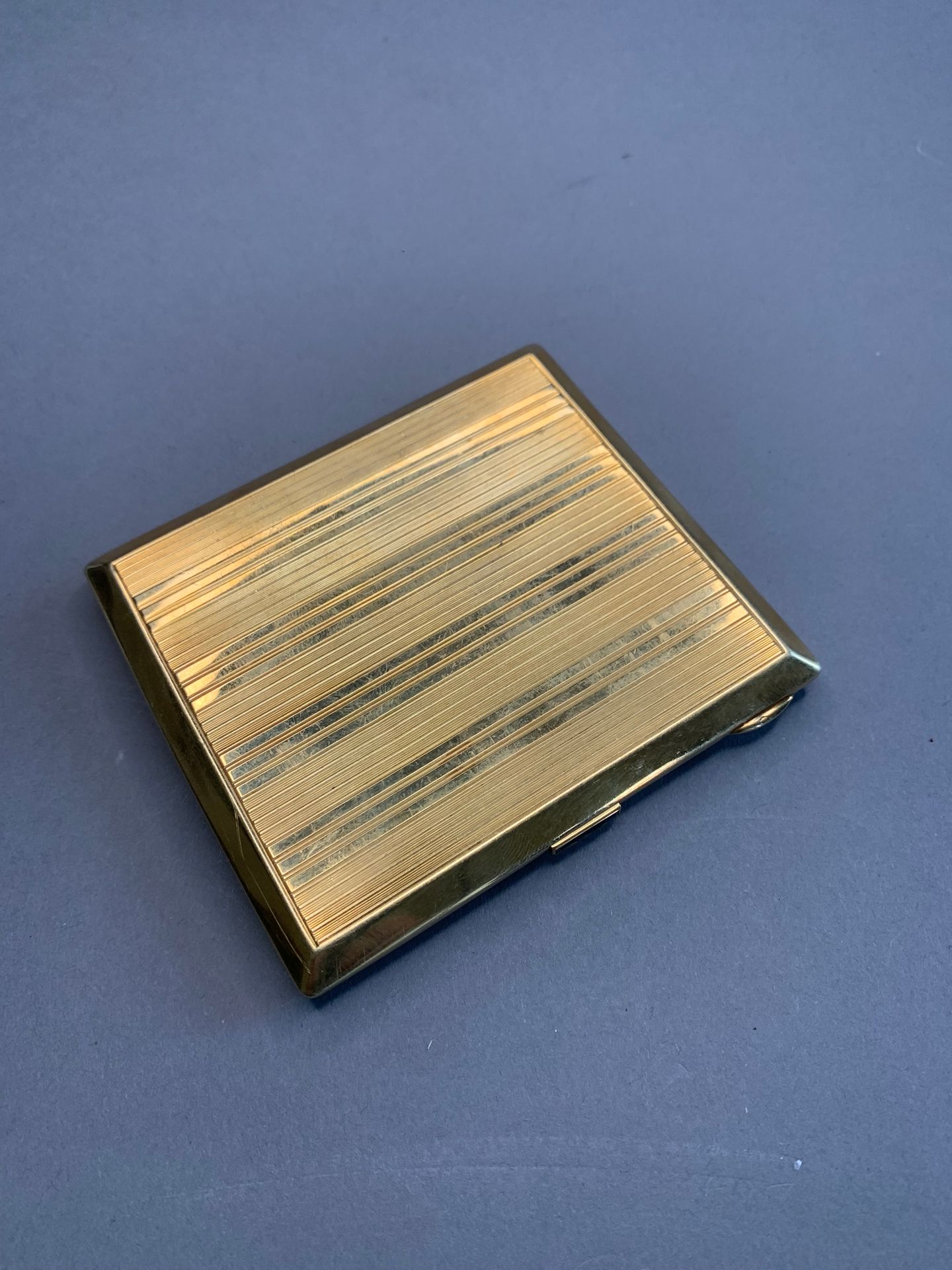 Null 18K黄金烟盒，带条纹的烟盒。
推杆上镶有4颗校准蓝宝石。
重量：142.9克