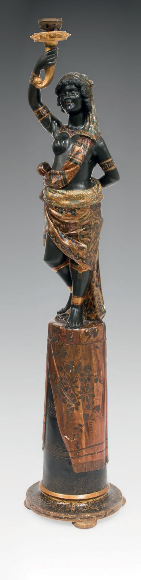 Null 木制火把架的彩绘和雕刻，表现了一个身着帷幔的努比亚妇女，她的右臂拿着火焰。
带底座的尺寸：高200 - 宽40 - 深40厘米
无底座尺寸：高120-&hellip;