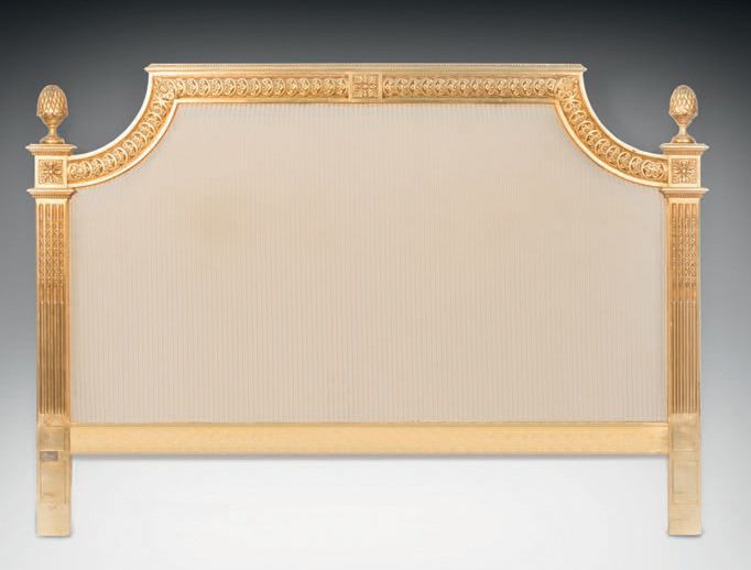 Null 路易十六风格的鎏金木床头板，模制和雕刻有风格化的花朵楣，有凹槽和鱼鳍的立柱，用奶油色和香槟色的条纹织物装饰。
H.145.5 - W. 224 - D&hellip;