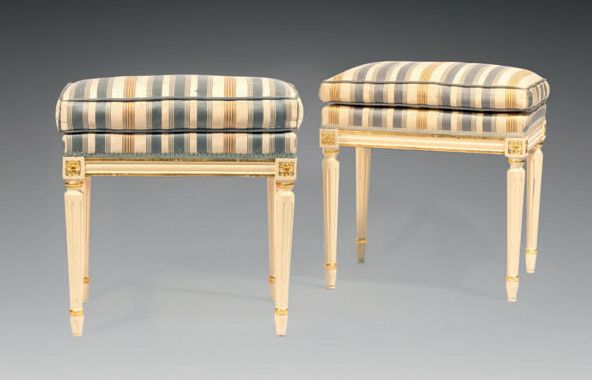 Null 两把路易十六风格的凳子，奶油色和镀金漆木，锥形和凹槽腿，奶油色背景上的蓝色和赭色条纹织物装饰。
H.53 - W. 50 - D. 38厘米