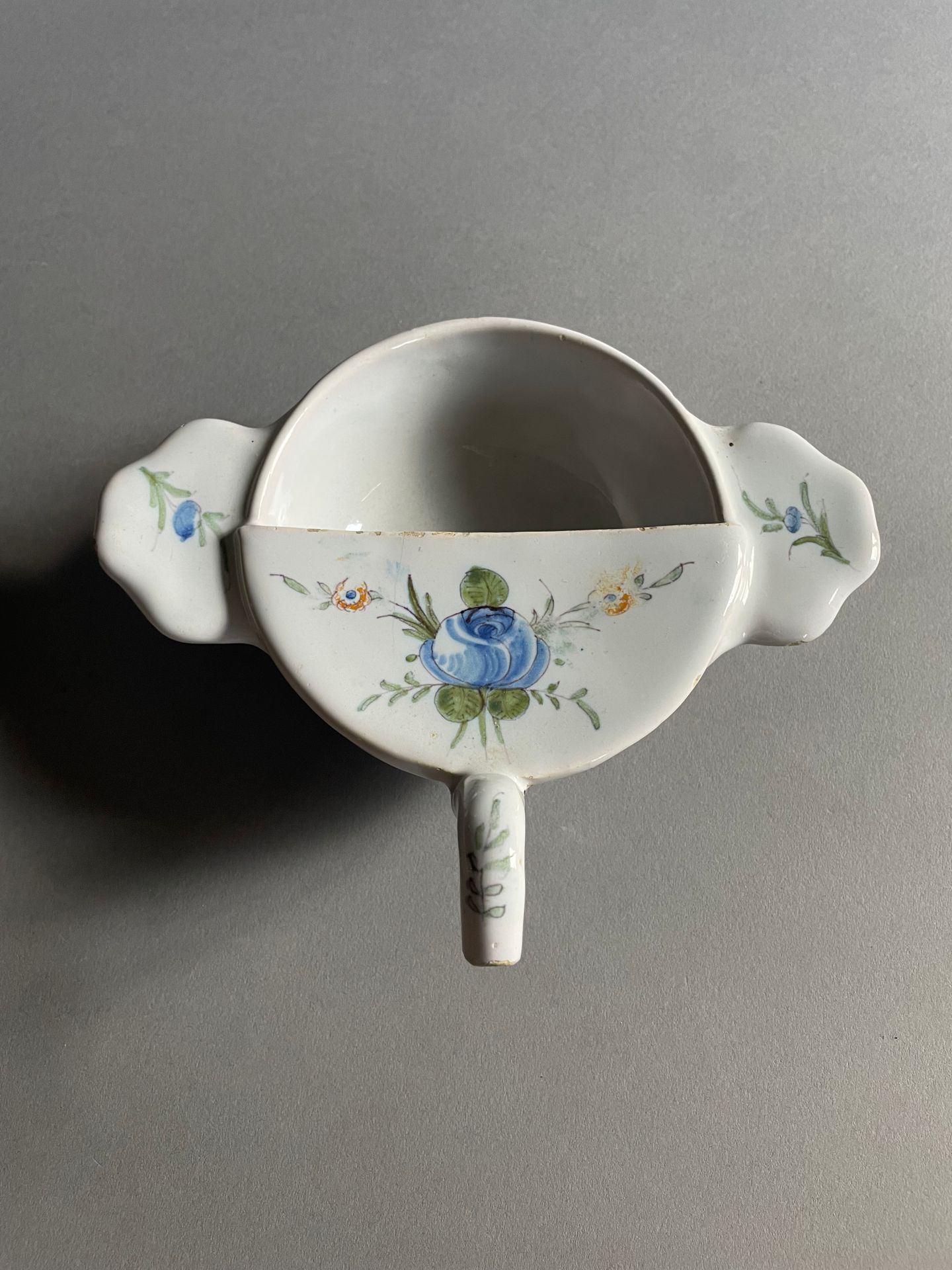 Varages 带两侧把手的圆形病鸭，陶器，多色花束和花茎装饰
十八世纪
长 20 厘米
(一个把手有缺口）