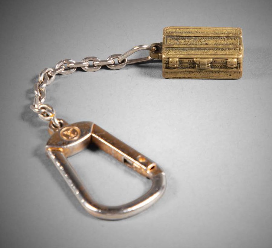 LOUIS VUITTON Malle" key ring in gilded metal
L. 12.5 cm
(Chain not original)