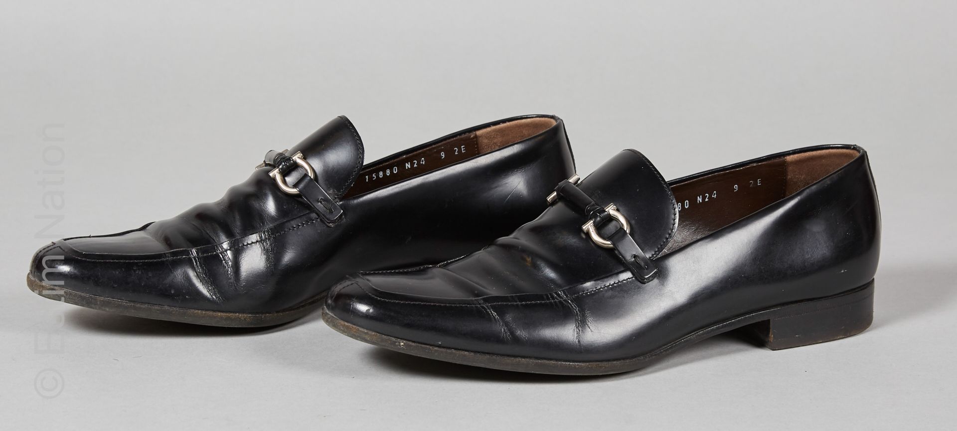 Salvatore FERRAGAMO Pair of moccasins in black glazed calfskin with a gilded met&hellip;