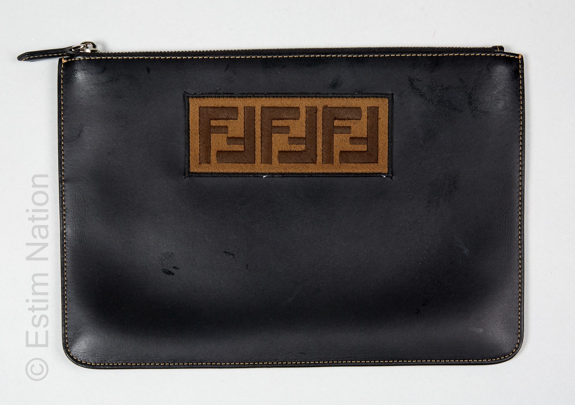FENDI 黑色皮革拉链口袋，绣有显示首字母的补丁（20,5 x 30厘米）（防尘袋）（皮革上有痕迹和标记）。