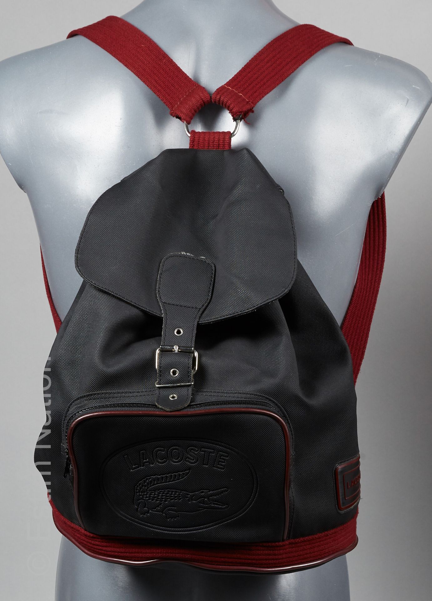 LACOSTE 黑色复合帆布背包，酒红色背带，前面有拉链口袋（38 x 30 x 11厘米）（非常轻微的痕迹）。
