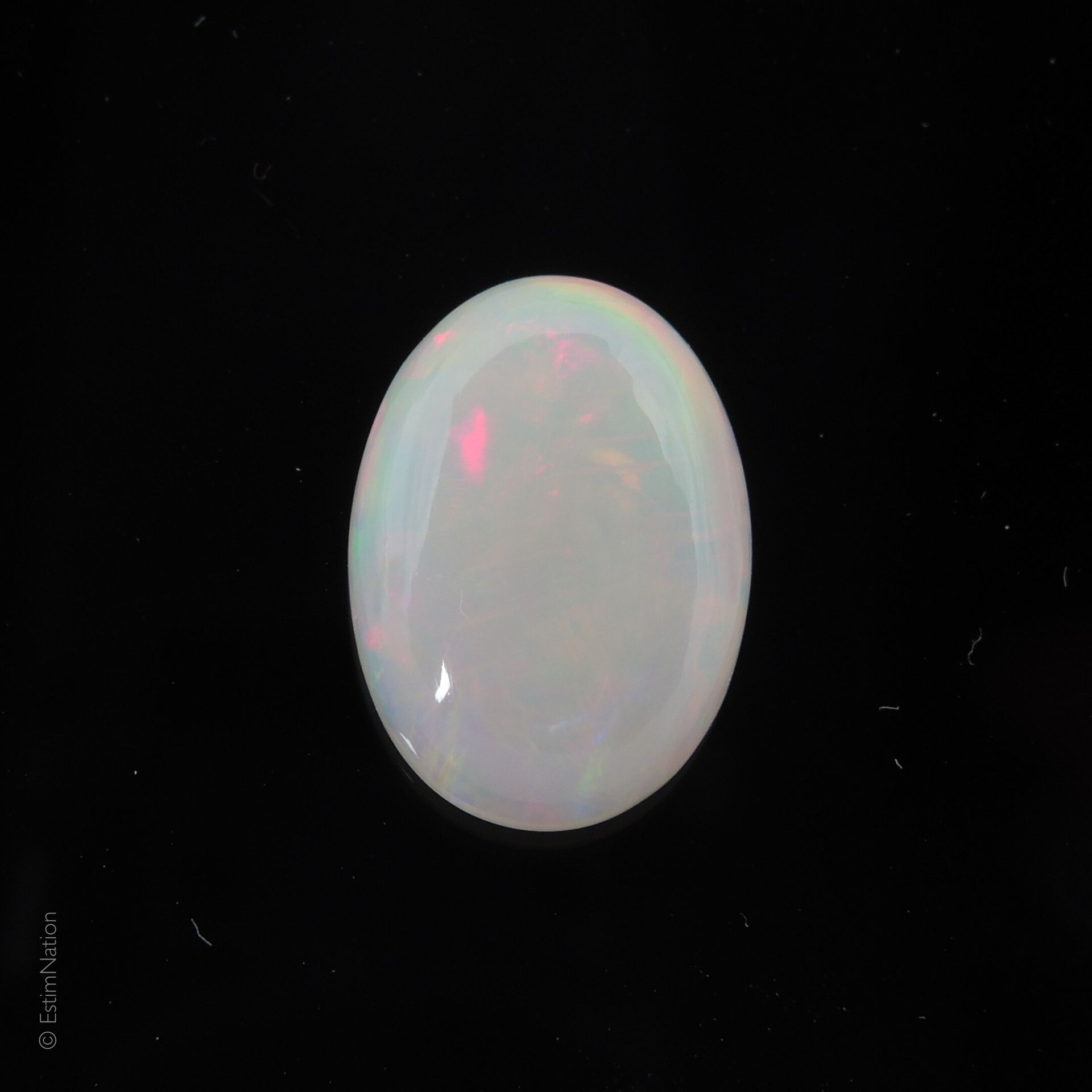 OPALE Une opale arlequin sur papier taillée en cabochon. Poids: 3,24 carats. Dim&hellip;
