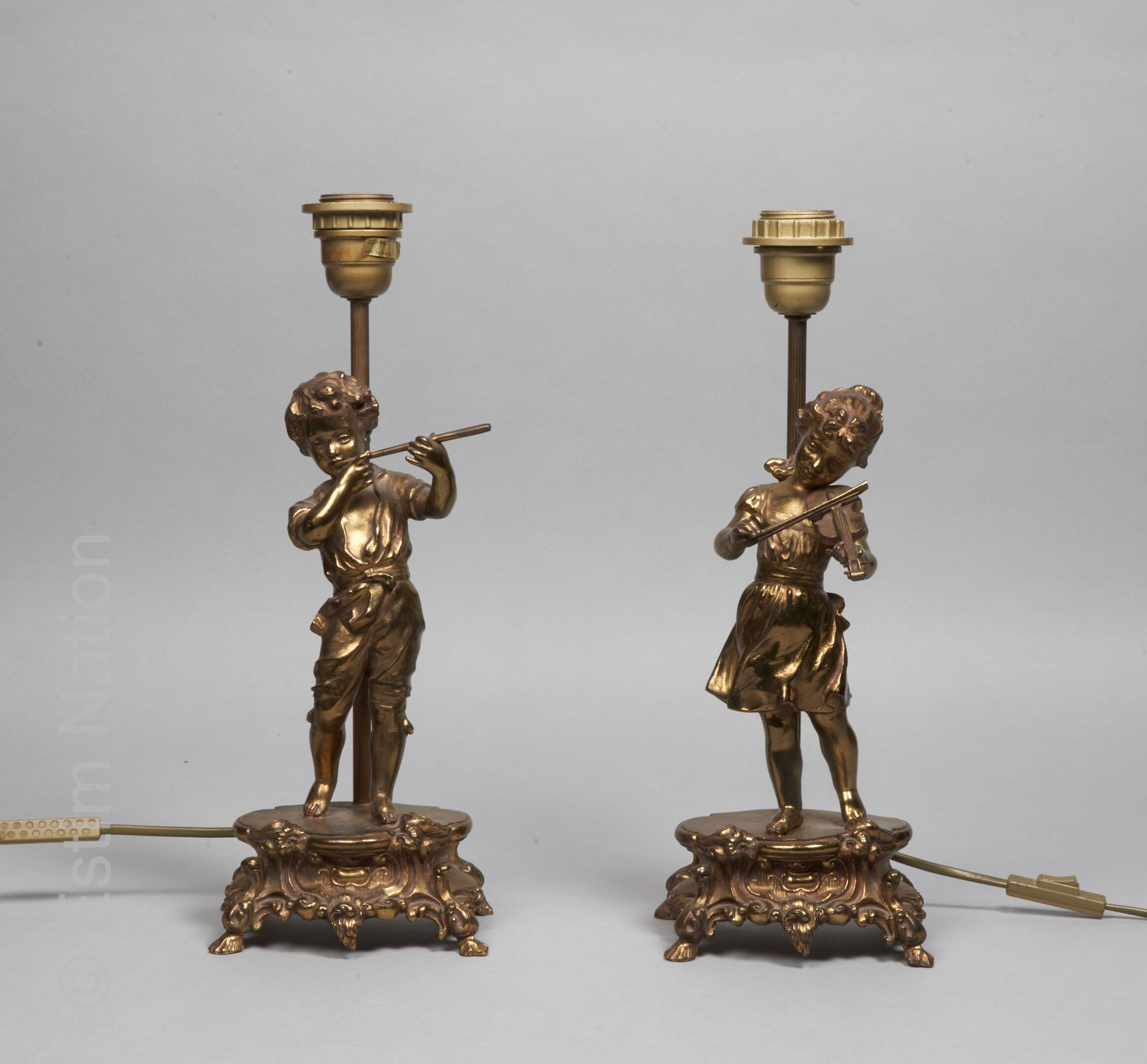 ARTS DECORATIFS Paire de lampes en métal doré, figurant un couple d'enfants musi&hellip;