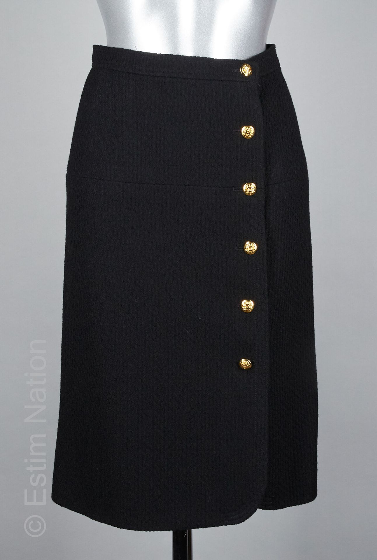 Skirt in black wool tweed with golden metal buttons sign…
