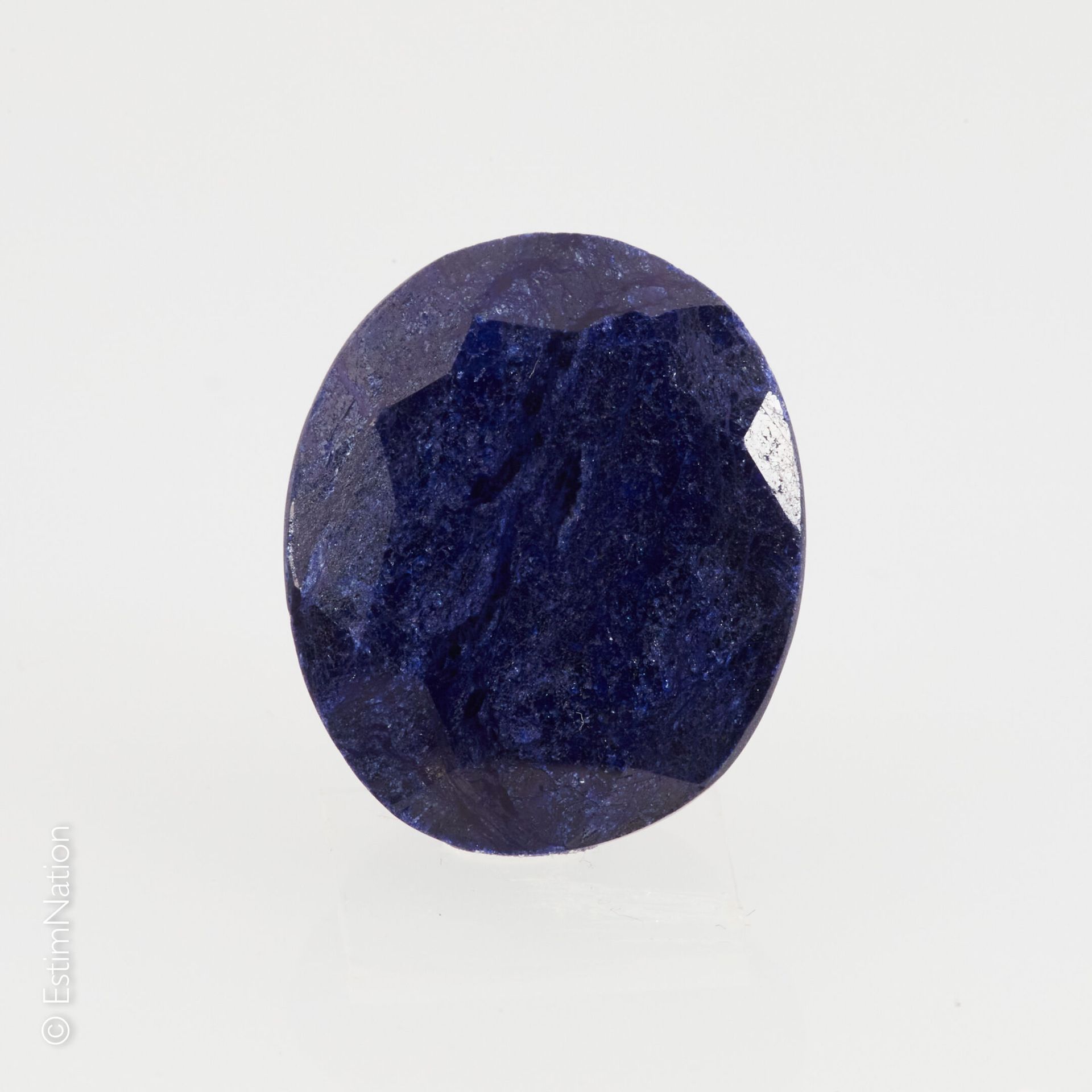 UN SAPHIR SUR PAPIER ET EXAMEN 一颗刻面的椭圆蓝宝石在纸上。尺寸：19.00 x 16.00 x 6.00 mm左右。重量：约18&hellip;