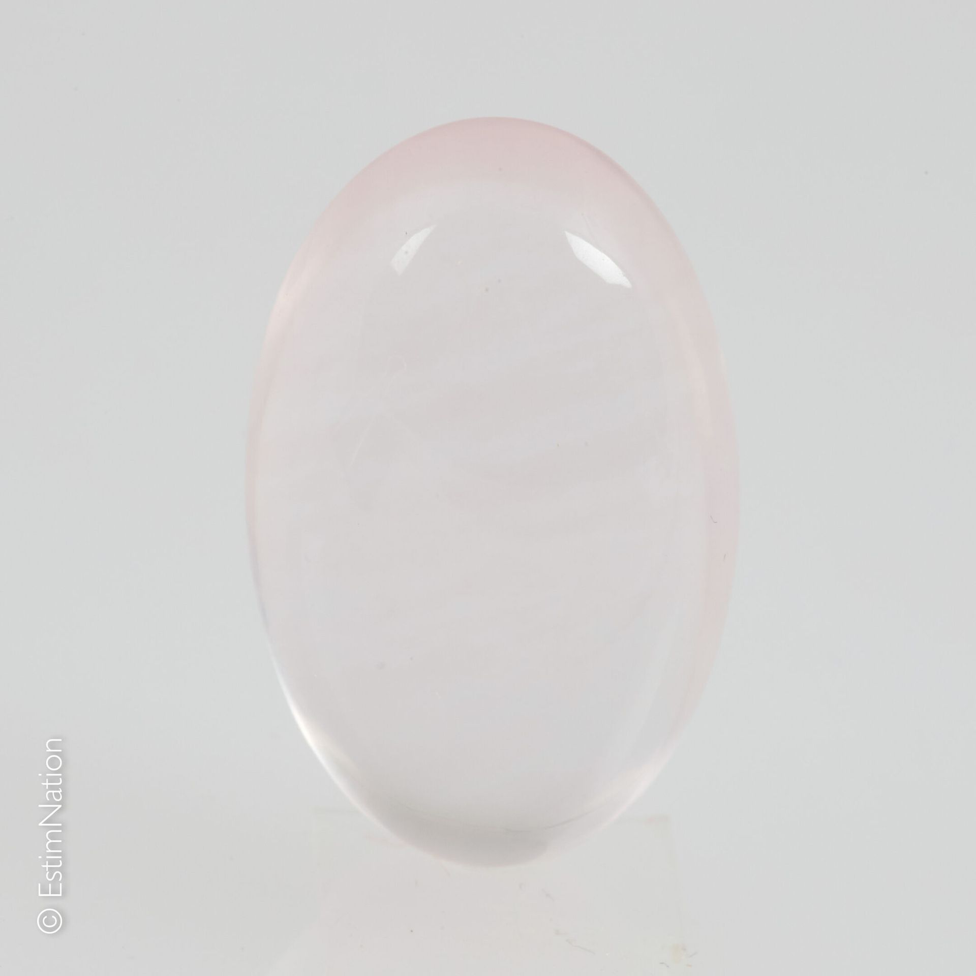 UN QUARTZ ROSE SUR PAPIER ET EXAMEN Un quartz rose sur papier de forme ovale tai&hellip;