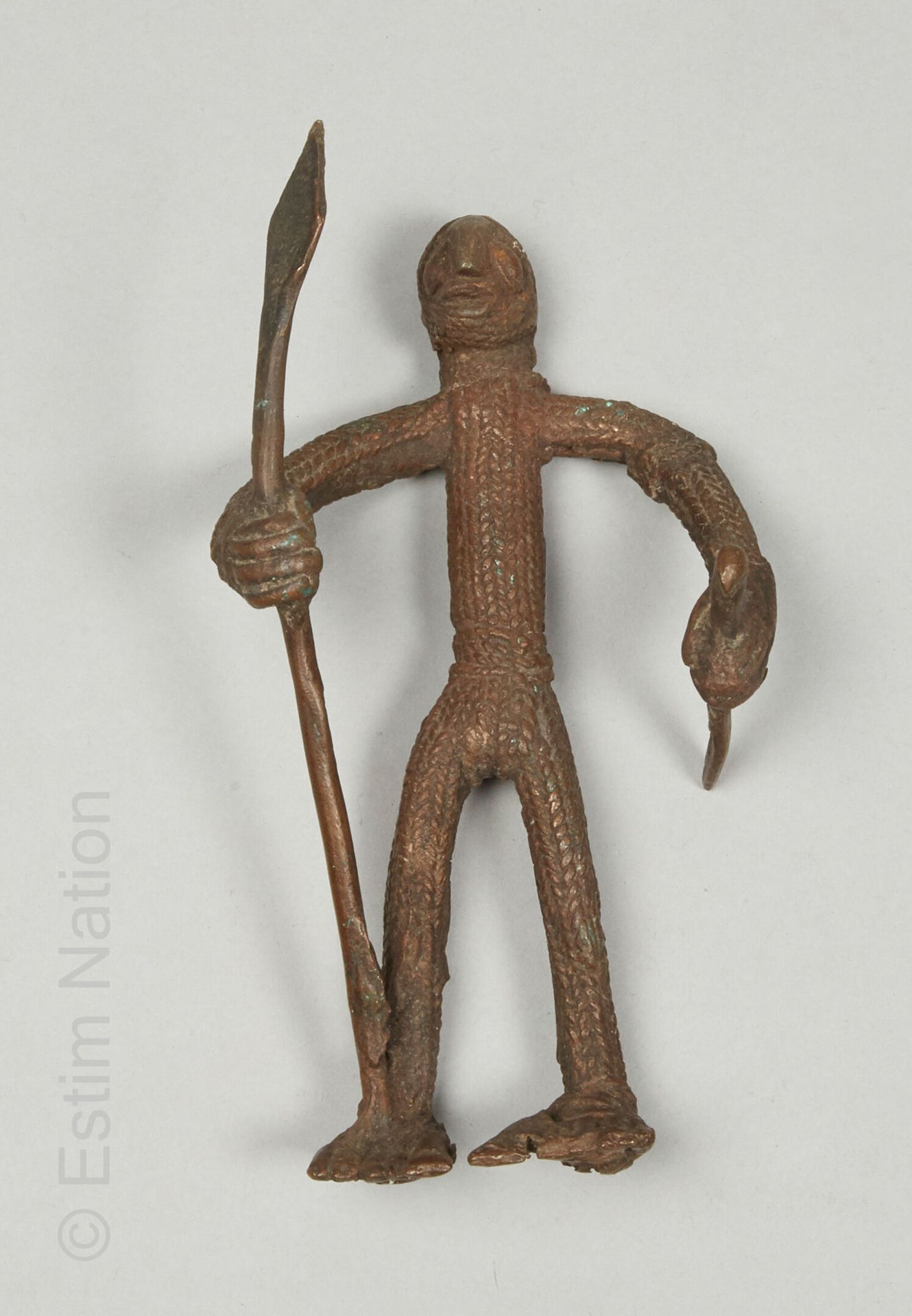 ARTS D'AFRIQUE 甘式雕像，布基纳法索
铜合金
H.18.5厘米

表现一个风格化的人物，一手拿着长矛，一手拿着短剑。身体以及头部的一部分都是纵横交&hellip;