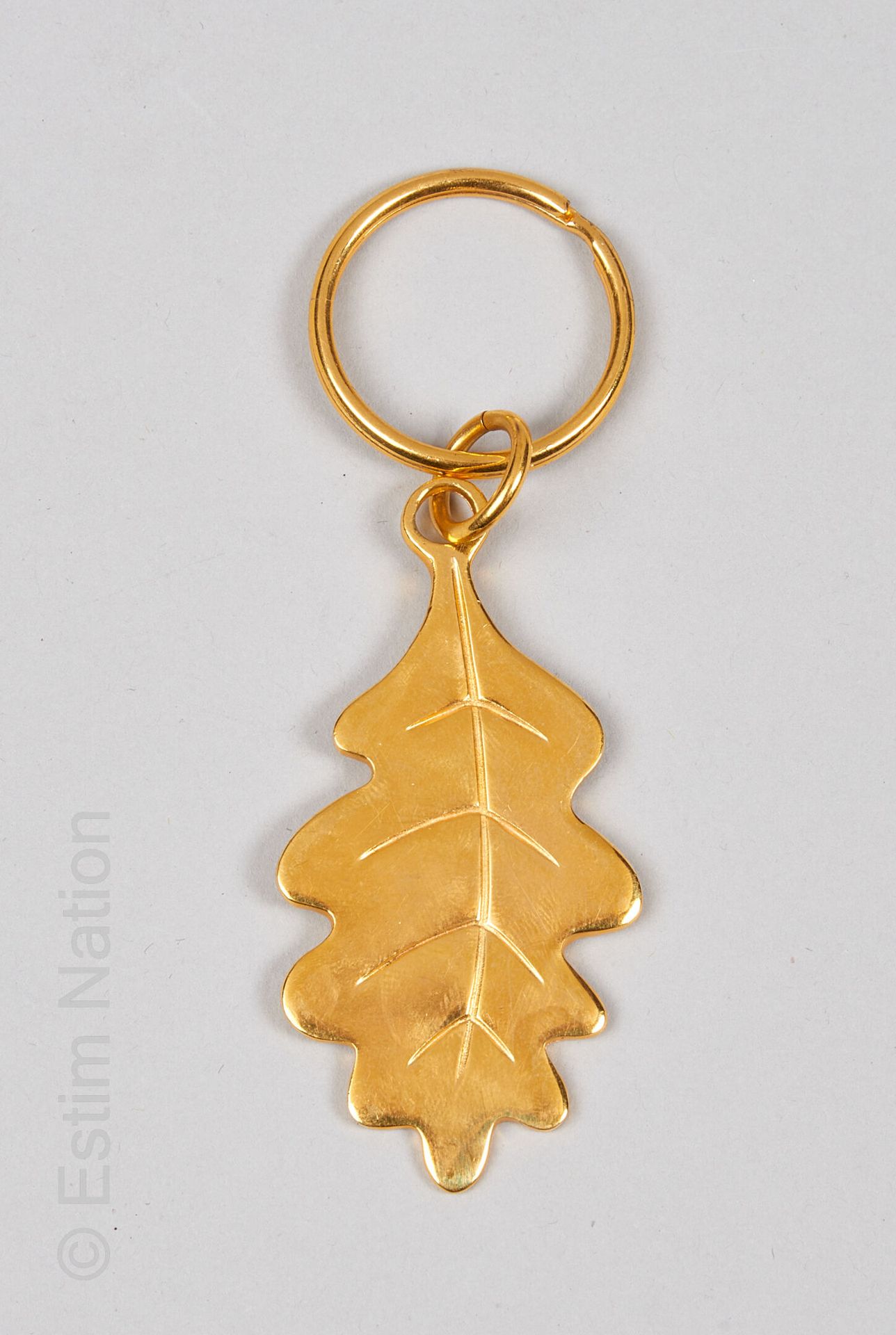 INES DE LA FRESSANGE Porte-clé doré et décoré d'une feuille de chêne, anneau dor&hellip;