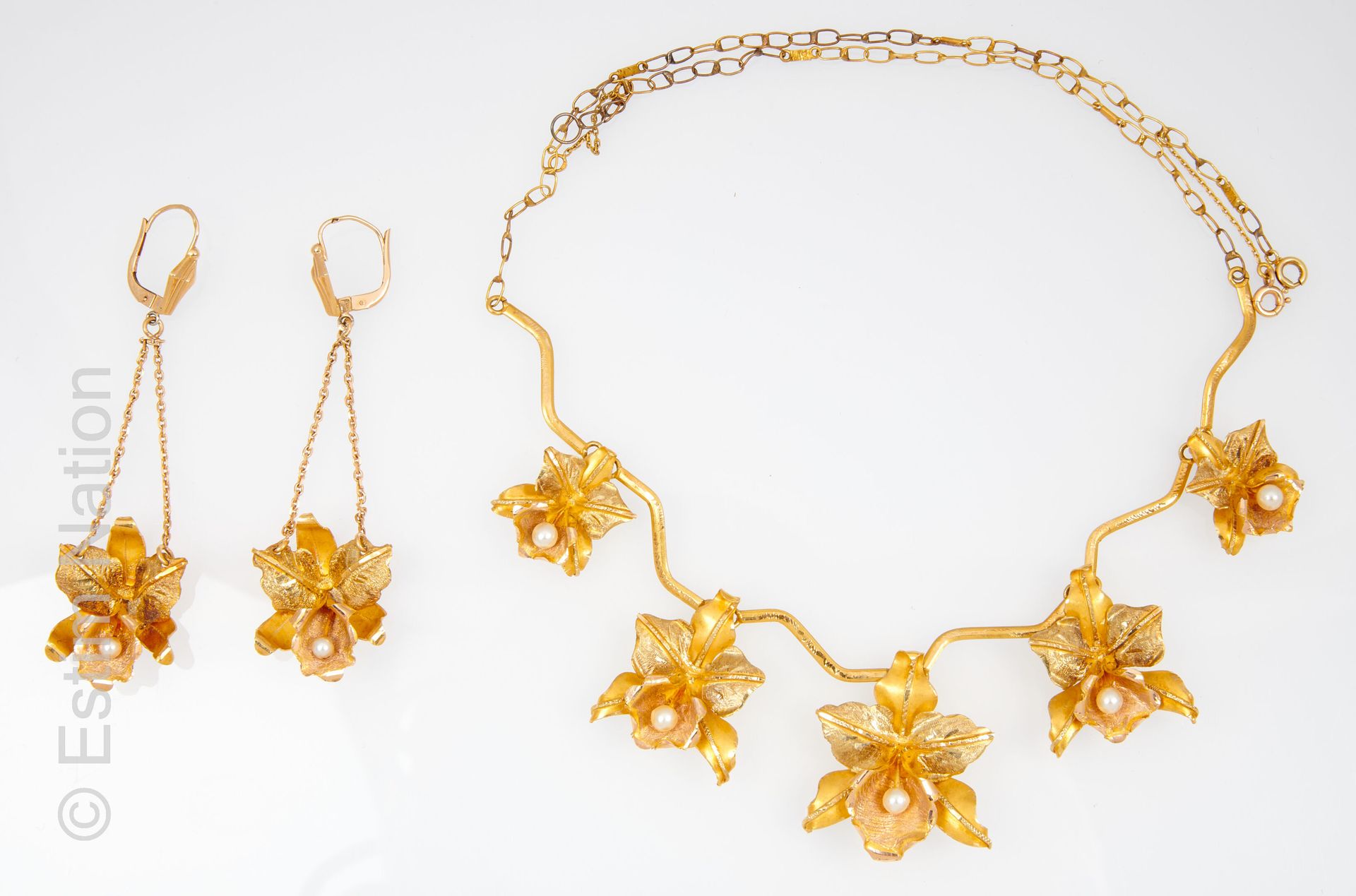 PARURE 镶嵌于14K（585/°）和18K（750/°）黄金中，包括一条项链、一条手链和一对耳环，上面装饰着光滑和凿刻的鸢尾花，花蕊上装饰着养殖珍珠。项链&hellip;