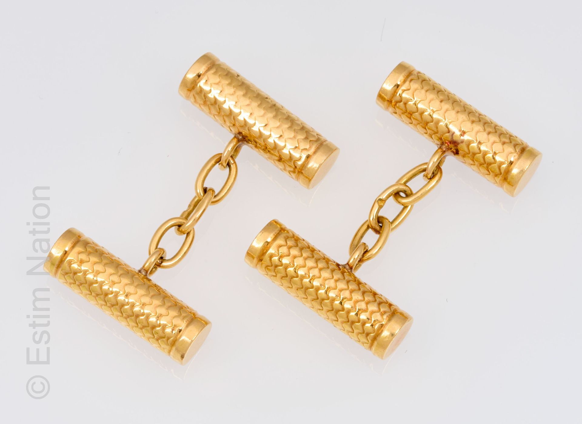 BOUTONS DE MANCHETTES OR JAUNE 一对18K(750千分之一)黄金袖扣，凿有鳞片的圆柱体。带链子的系统。法国作品，重7.3克。