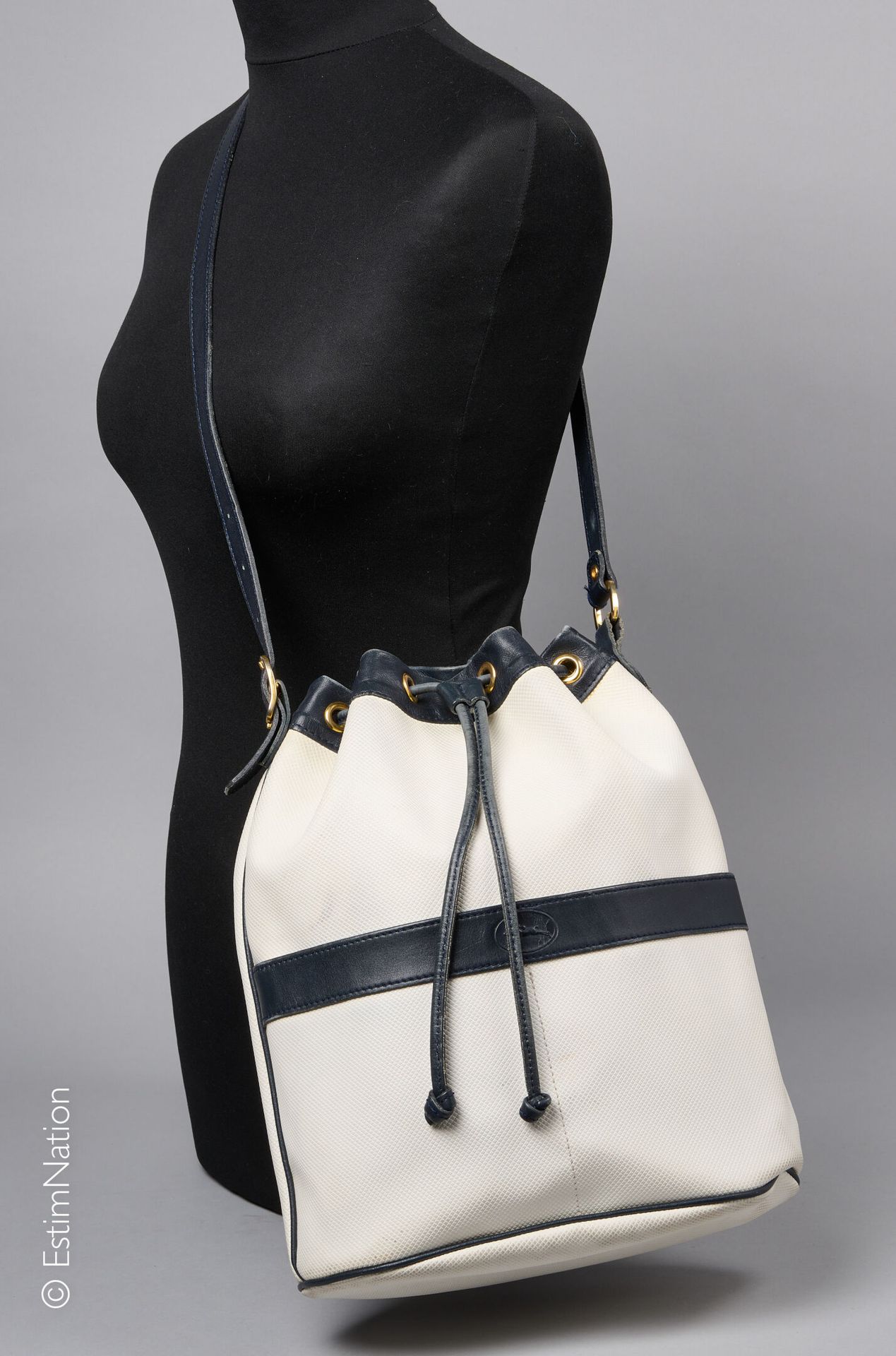 LONGCHAMP VINTAGE 白色复合帆布和海军皮革水桶包，复合帆布衬里（31 x 27 X 11厘米）（边缘的皮革有污垢和磨损）。