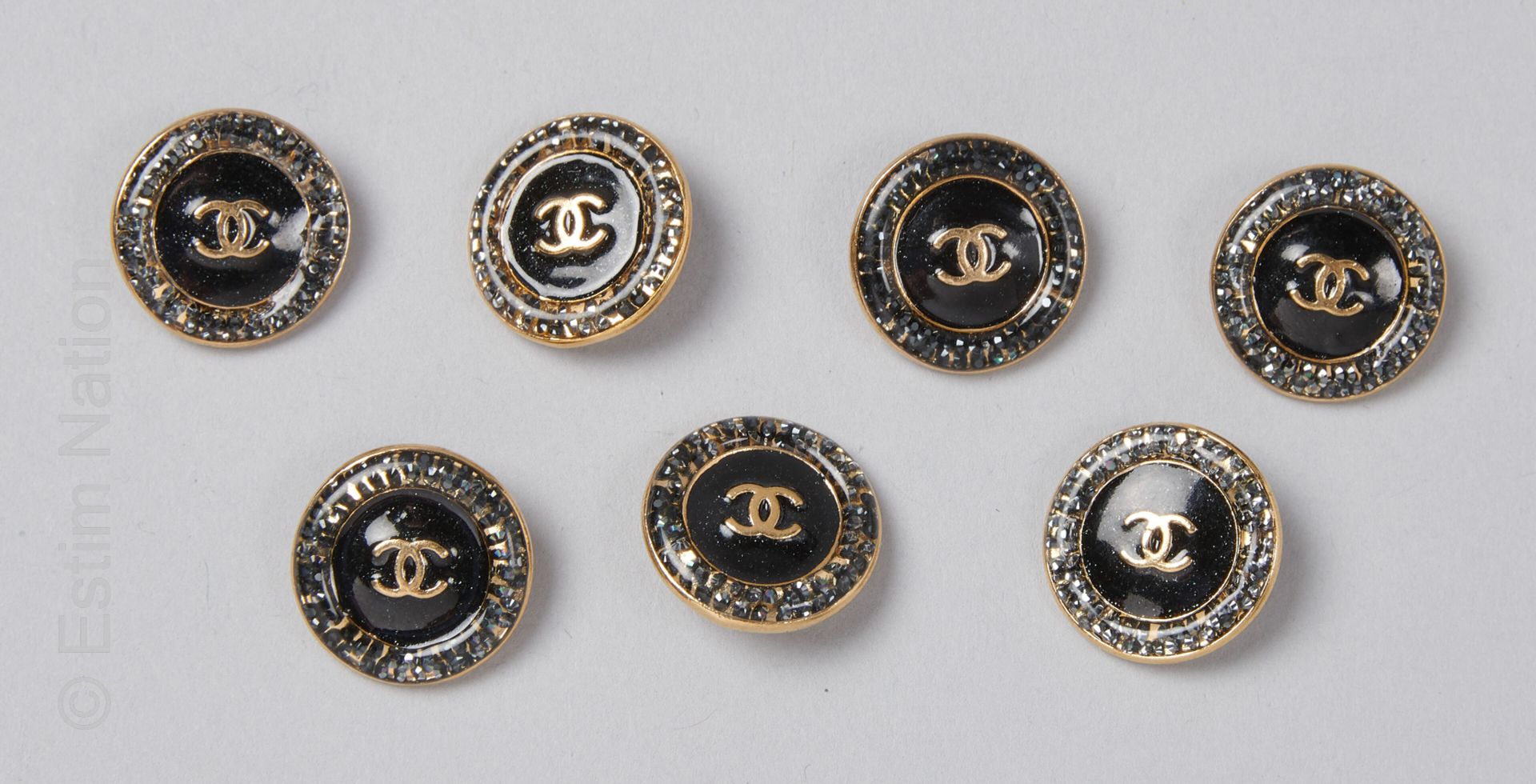 CHANEL SET DE SEPT BOUTONS en métal doré émaillé noir et strass (diam : 1,6 cm) &hellip;