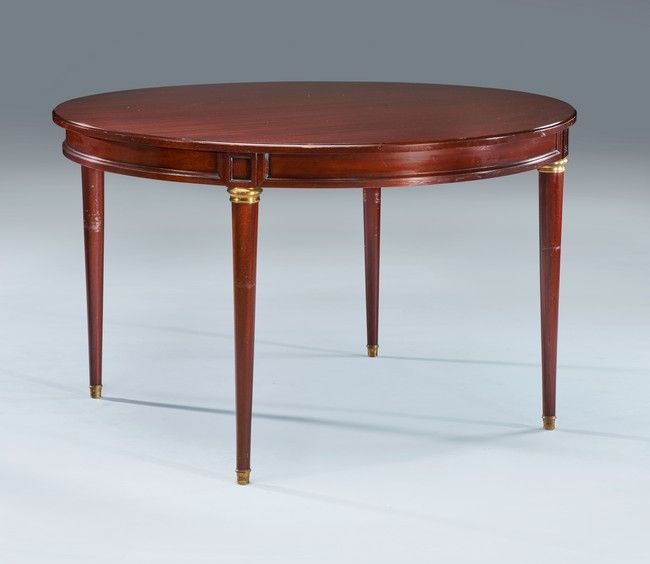 Null 圆形餐桌，模制和染色的木材，桃花心木风格，锥形腿，带镀金的铜环。

路易十六的风格。

高度80厘米，直径126厘米