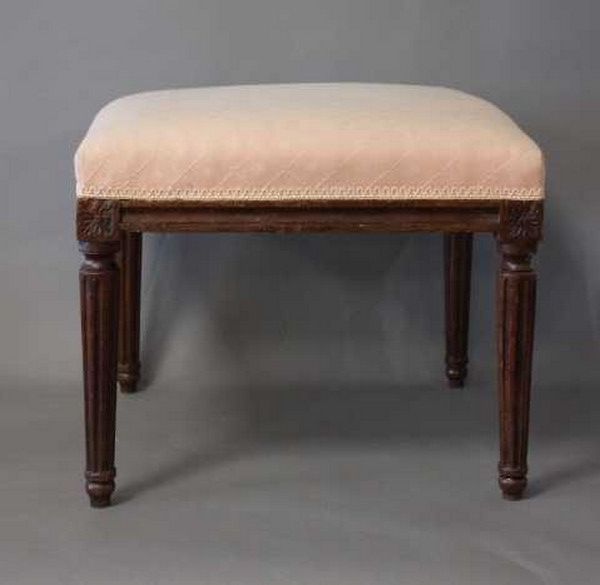 Null 方形的TABOURET，染色榉木，锥形和凹槽腿。

路易十六时期。

粉红色的棉布装饰。

高40厘米；47 x 47厘米。

(虫洞)