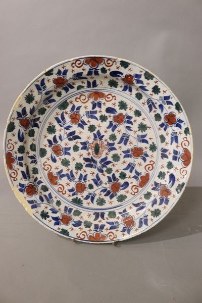 Null 大型圆陶盘，施以三种颜色的釉，饰以花纹。

代尔夫特，18世纪

直径35厘米

(边缘有裂痕和缺失的珐琅质)