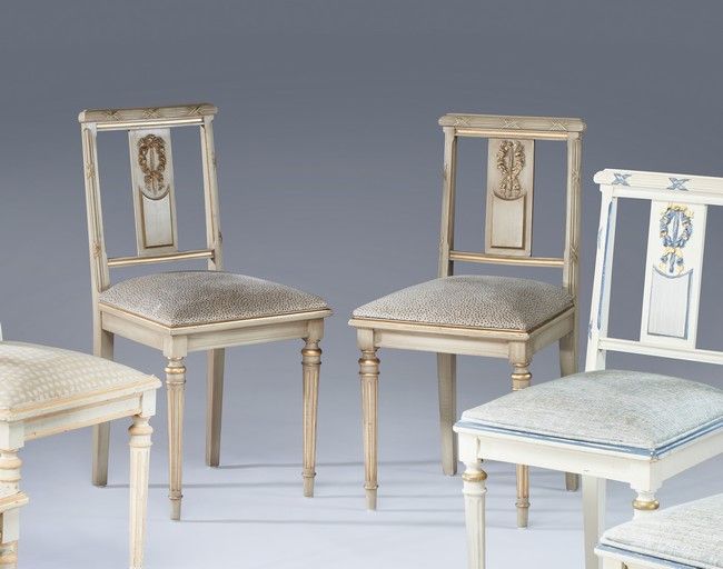 Null 一对镂空平背椅，木雕，奶油色漆和金色亮点，装饰有带状花环，靠在有凹槽的前腿上，马刀形后腿。灰色带点的软垫。

路易十六风格

高度90厘米