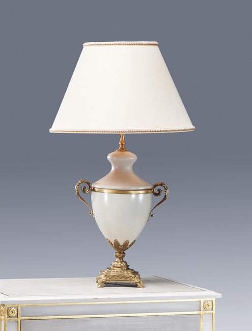 Null 一个米色裂纹陶瓷灯，周围有鎏金铜，有两个滚动的把手，放在一个方形的底座和四个小滚动的脚。

路易十六风格

高度：47厘米