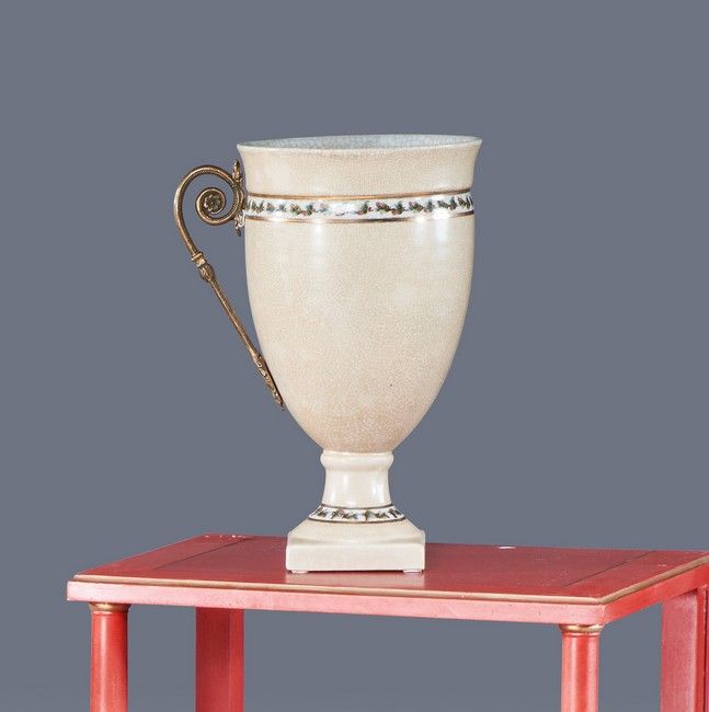 Null 一个米色裂纹陶瓷柱形花瓶，有一个多色珐琅彩的叶子花环楣，和一个以刺桐叶为结尾的弯曲形式的鎏金青铜支架。橙色的Mark G C。

高度34厘米