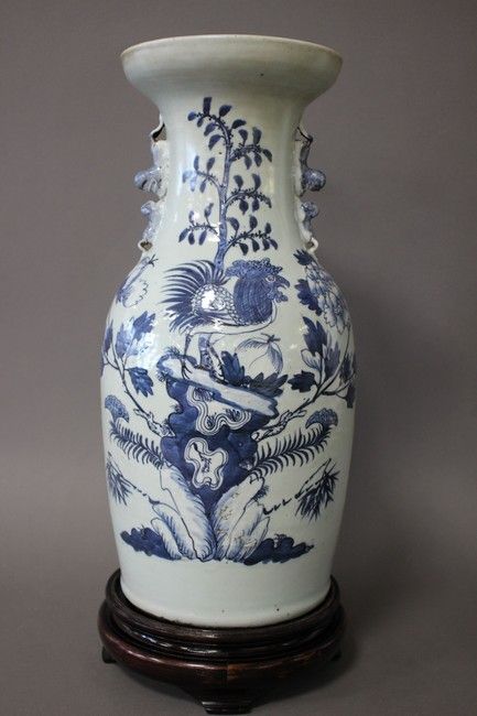 Null 中国，19世纪末

青花珐琅彩阳台花瓶，装饰有一只公鸡栖息在花石上，小把手为对峙的狮子形式。

高43厘米

(颈部有裂纹，珐琅质有小的缩进，底部未钻&hellip;