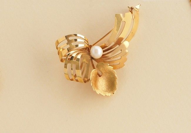 Null BROCHE en or jaune (750) de forme noeud ajouré serti d'une feuille et perle&hellip;