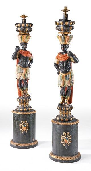 Null 一对大型镀金和多色雕刻的木制手杖，表现努比亚人在古代风格中打扮成印第安人，圆柱形的底座上有奖章。
意大利，19世纪末。
高180厘米
(改用电，一只手&hellip;
