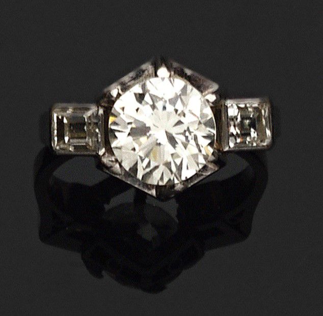 Null 一枚白金和铂金戒指，镶嵌着一颗明亮式切割钻石和两颗长方形钻石。

钻石重量：约2,74cts

毛重 : 8,33 g

M/VS2