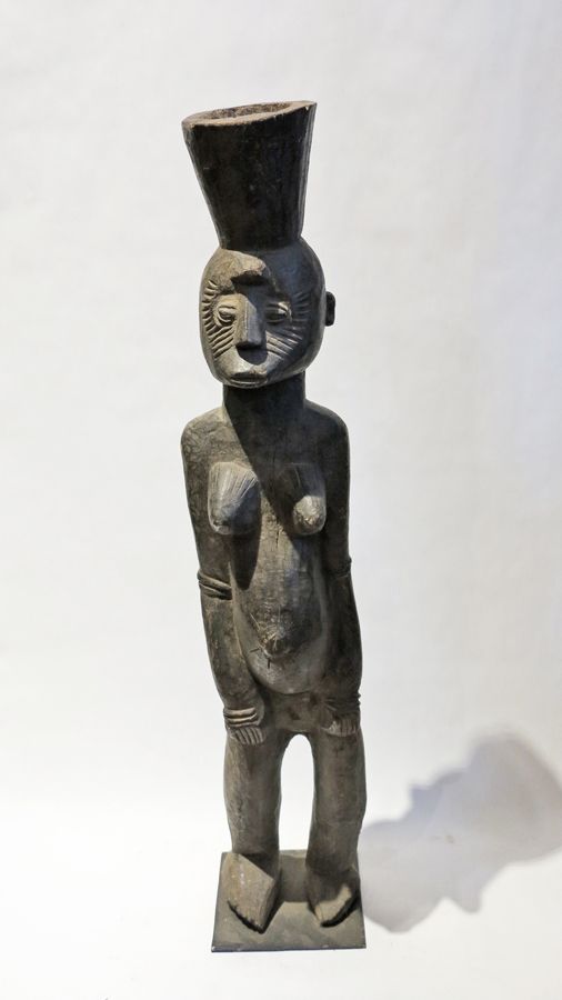 Null 女性雕像，有特征性的疤痕，她是站着的，手臂沿着身体，双手放在大腿的前面。 
象牙海岸，塞努弗族。高：102厘米