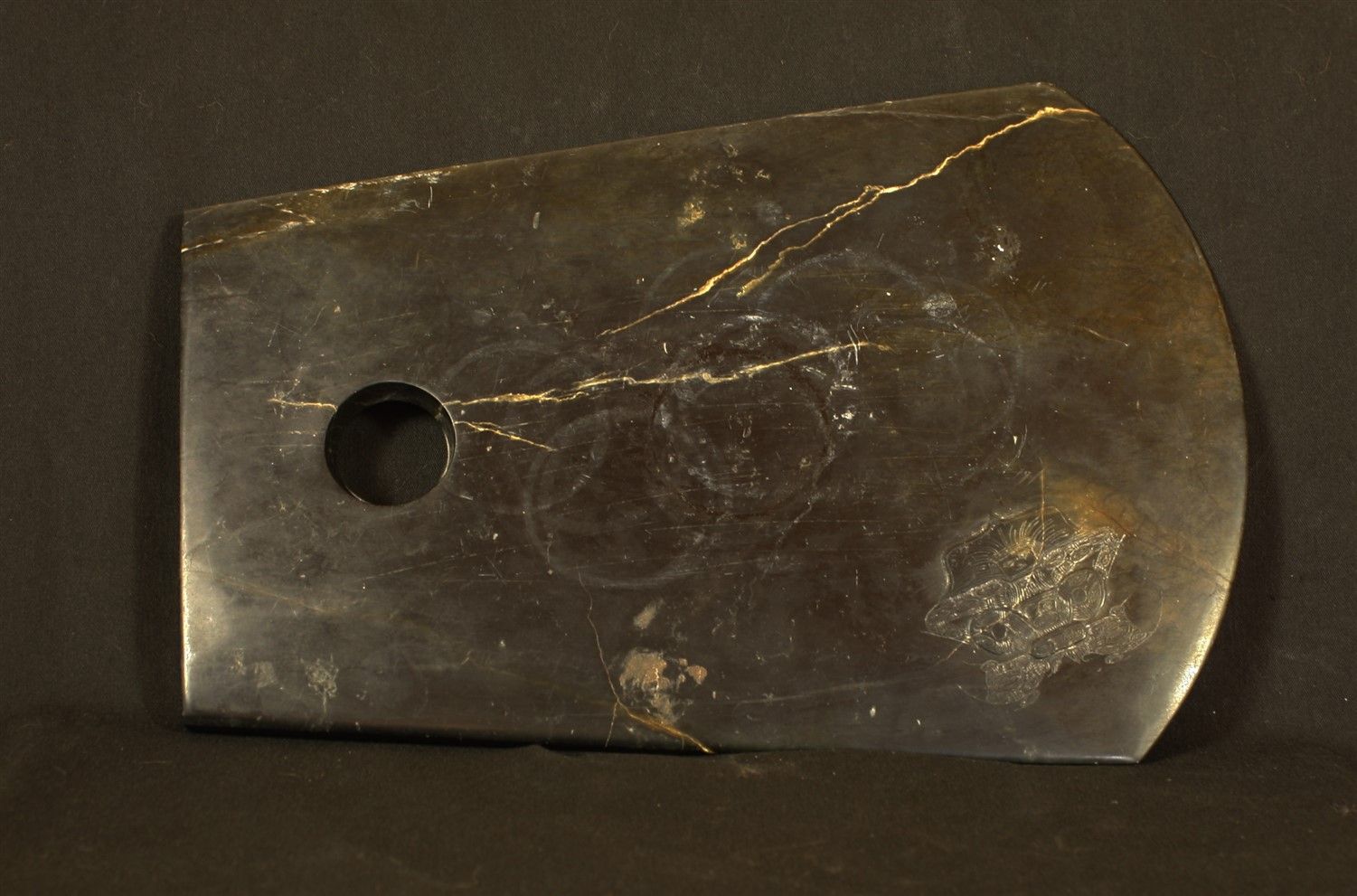 Null Axt aus Stein mit einem Löwenmotiv. 
China, 28,5X19cm