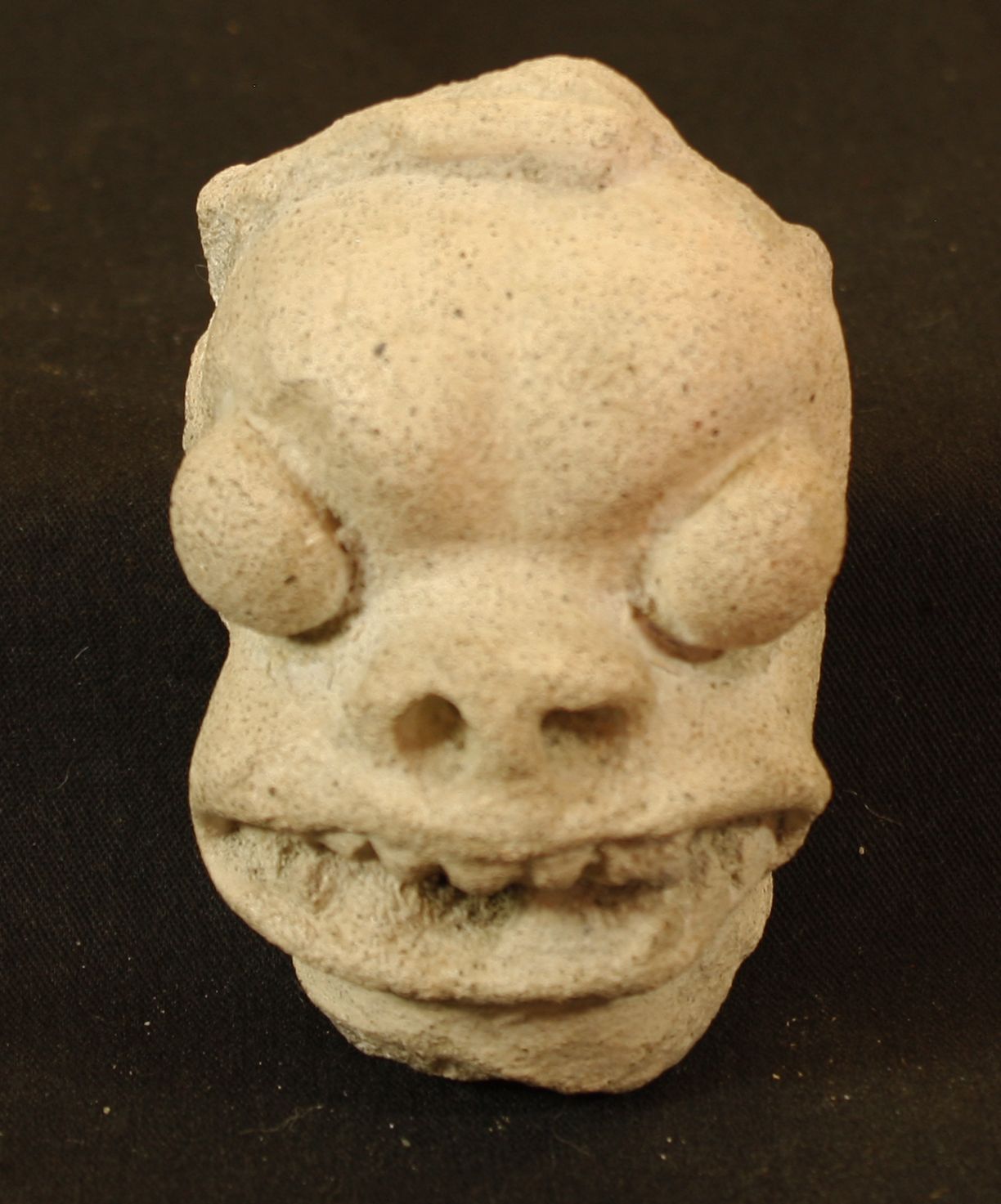 Null Terrakotta-Kopf mit Glubschaugen, schmaler Nase und einem bedrohlichen Läch&hellip;