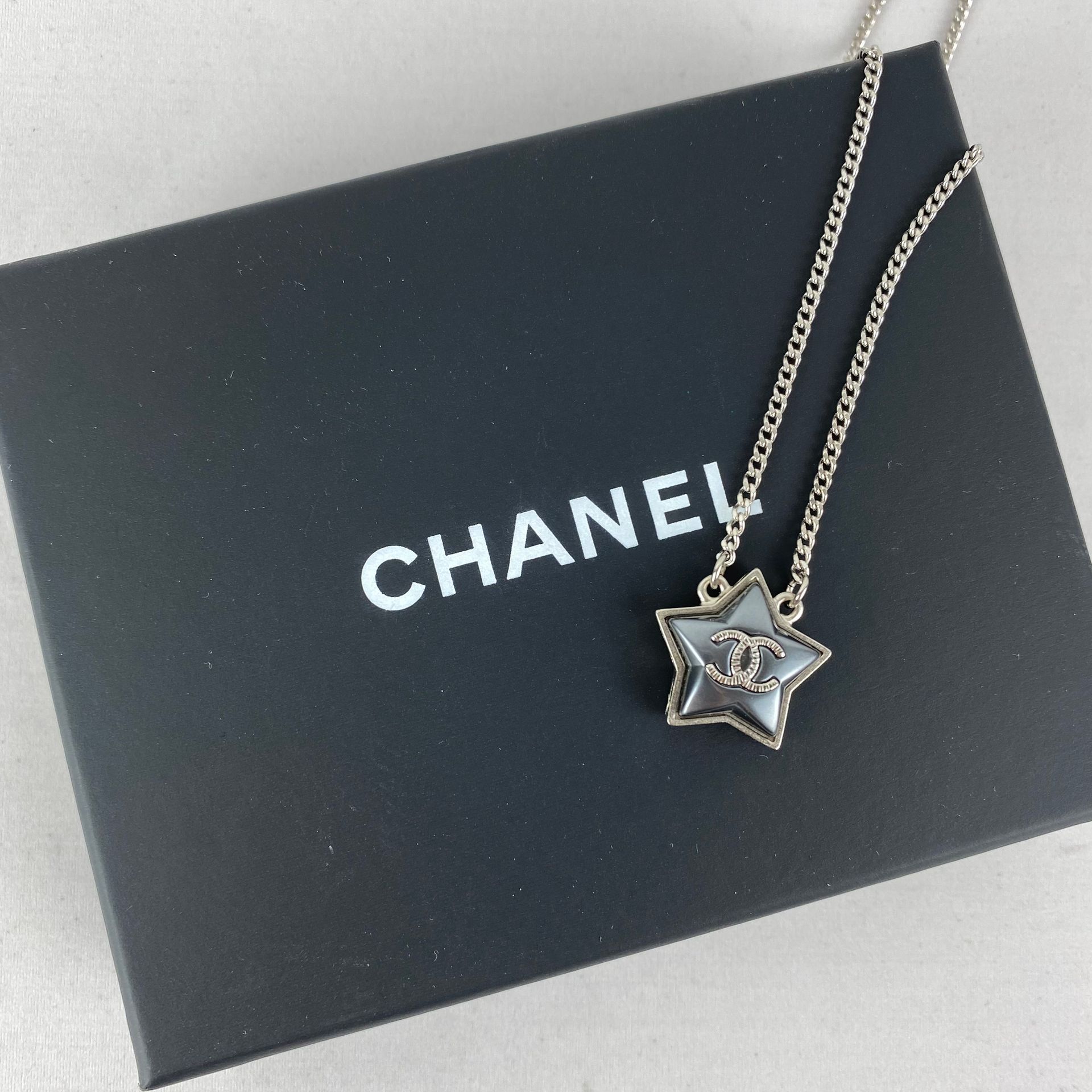 CHANEL 1 collier CHANEL en métal argenté avec pendentif étoile fantaisie, chaine&hellip;