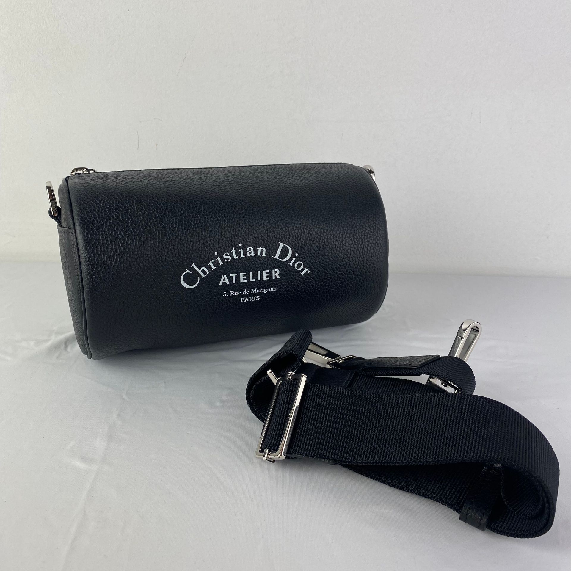 DIOR Une pochette DIOR modèle Atelier Roller Bag en cuir noir avec bandoulière d&hellip;