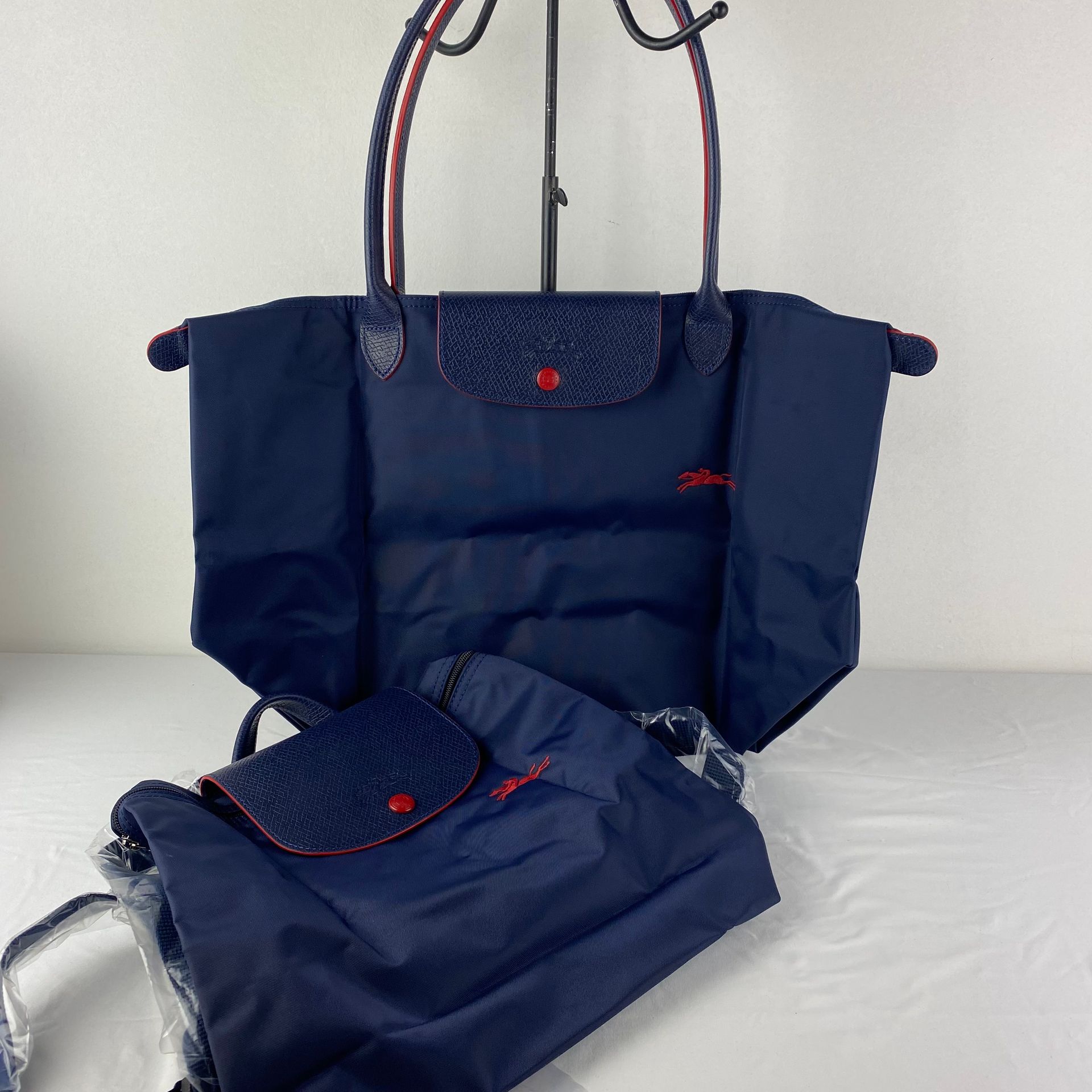 LONGCHAMP 一套2个LONGCHAMP帆布和皮革包，海军色，红色镶边，型号Pliage，1个购物袋，尺寸47/30厘米，米色，1个背包，尺寸23/28厘&hellip;