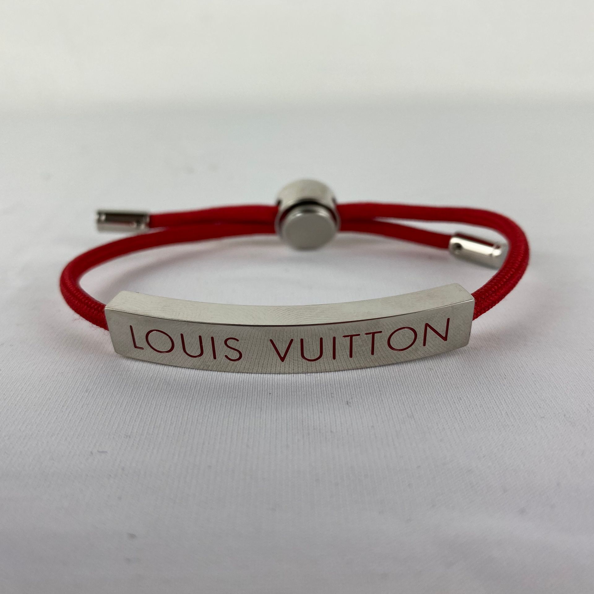 LOUIS VUITTON Un bracelet LOUIS VUITTON modèle LV Space cordon rouge ajustable a&hellip;