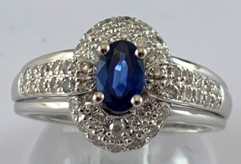 Null 18K白金戒指，5g75，在48颗圆形现代钻石中镶嵌一颗椭圆形蓝宝石，重达1克拉。TTD: 53.