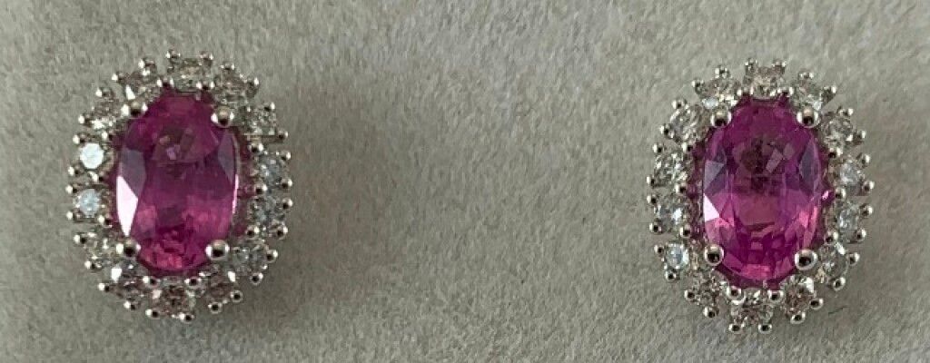 Null 一对18K白金耳环，镶有两颗椭圆形的粉色蓝宝石，总重1.30克拉，周围有28颗钻石，总重0.40克拉。比利时推杆式表扣。