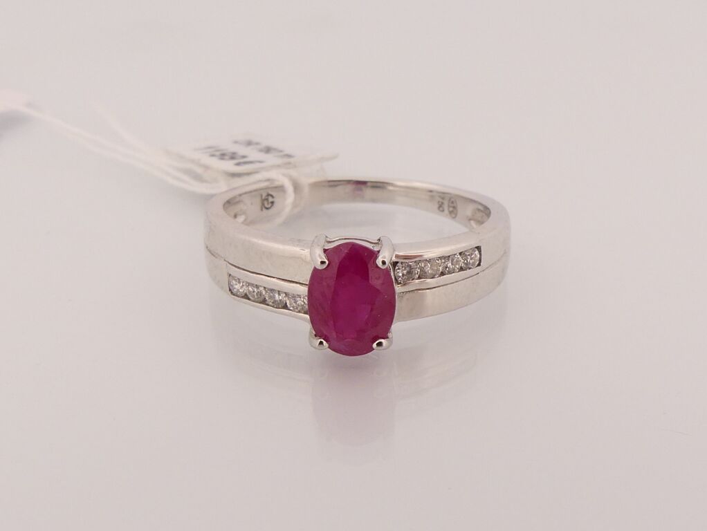 Null Ring aus Weißgold mit einem Rubin im Ovalschliff, der von kleinen Diamanten&hellip;