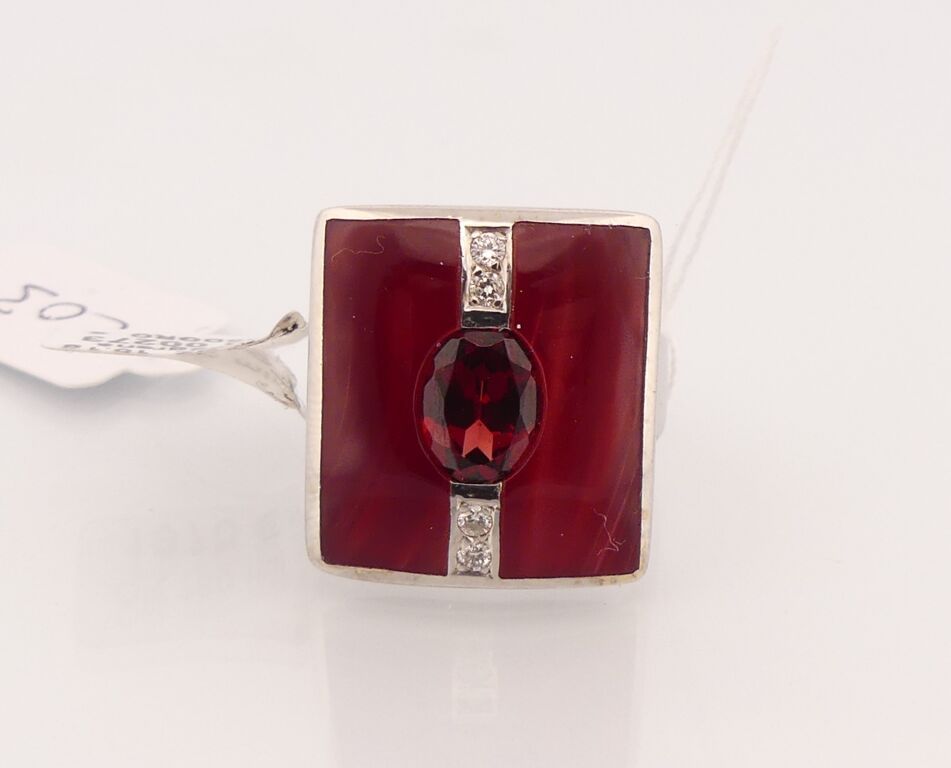 Null White gold ring centered with a garnet and a round diamond. TDD : 54. PB : &hellip;