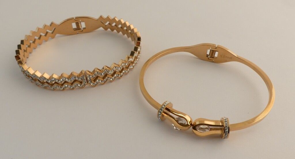 Null Two gold metal bracelets, decorated with swarovski stones, jewelry style.