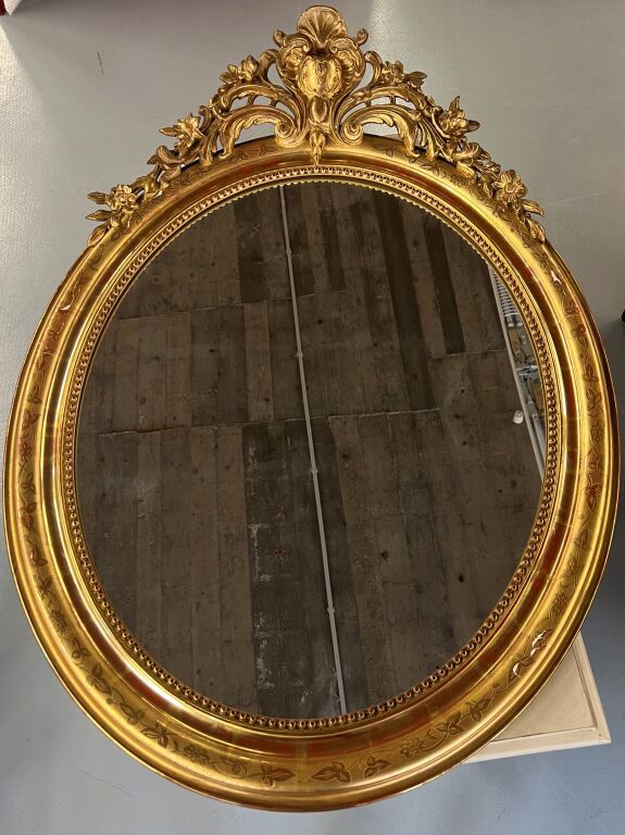 Null Wooden and gilded stucco oval mirror with pediment. Height : 116 cm.