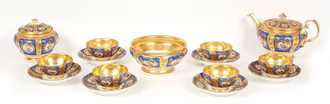 Null 金色和蓝色背景的瓷器茶具的一部分，包括六个杯子和碟子，一个饼干杯，一个茶壶和一个糖碗的多色装饰。(一个裂缝到一个杯子)。卡波迪蒙特 19世纪末，20世&hellip;
