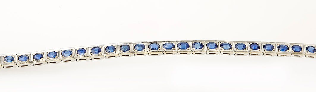Null 18K(750/°)白金线条手镯，铰接式链节，中心为封闭式镶嵌的椭圆形蓝宝石。长度：18厘米 毛重：18.9克