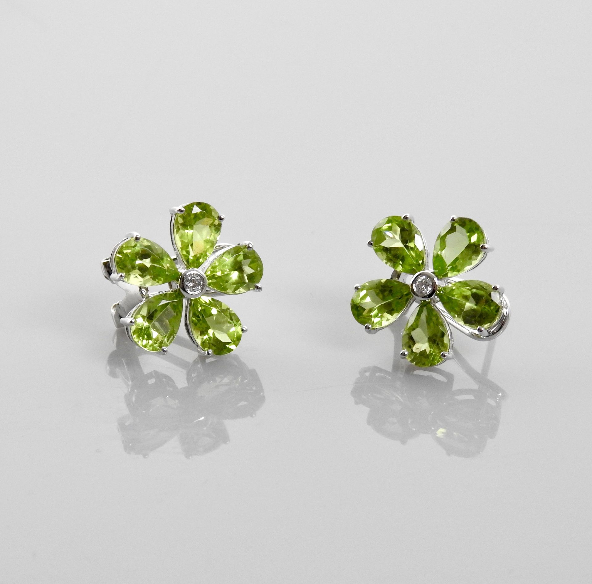 Null 白金耳环，750毫米，每只耳环上都有围绕钻石的橄榄石装饰，重量：2.7克。