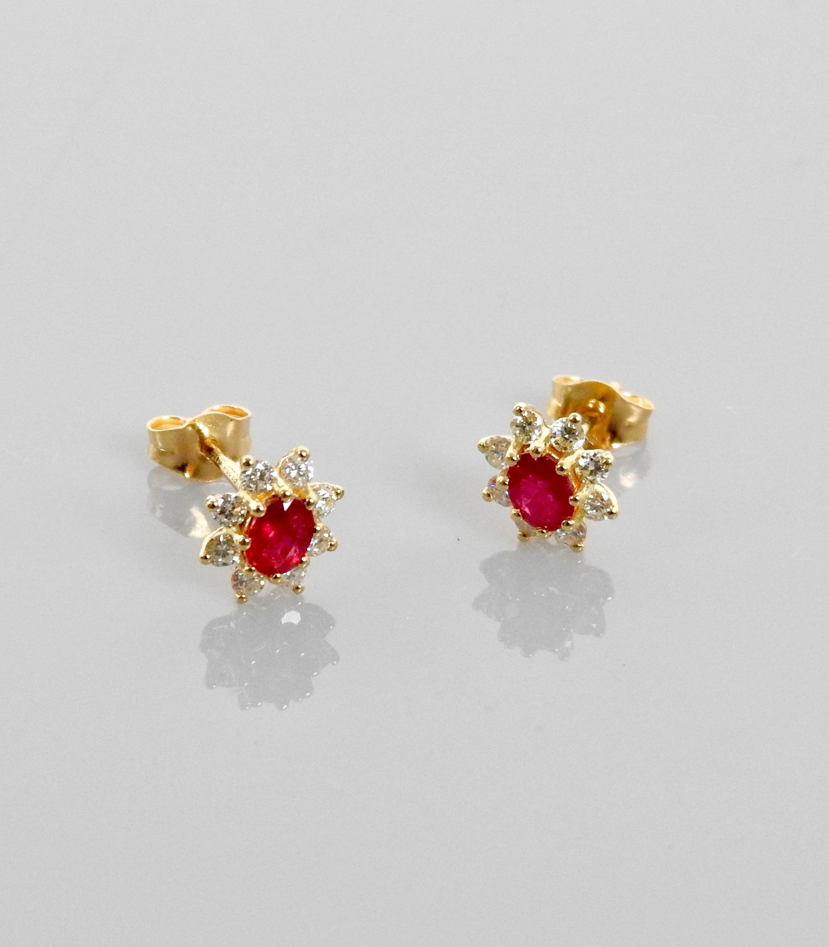 Null Earrings drawing a yellow gold floret, 750 MM, each centered with a ruby su&hellip;